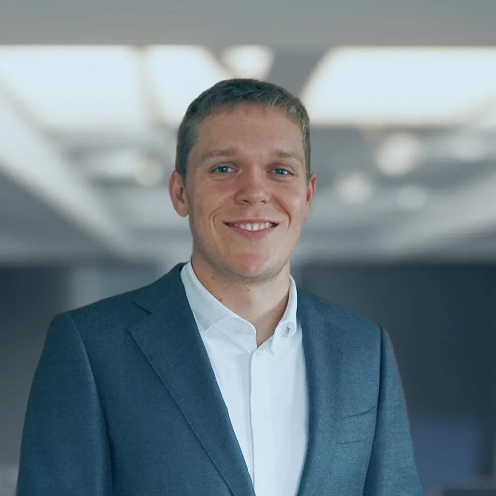 Adam Hjelmar i blazer og hvid skjorte i et kontor